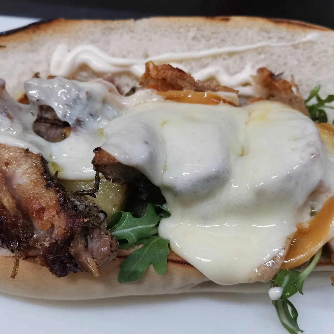 Panino alla piastra con porchetta croccante, provola fusa, patate e rucola